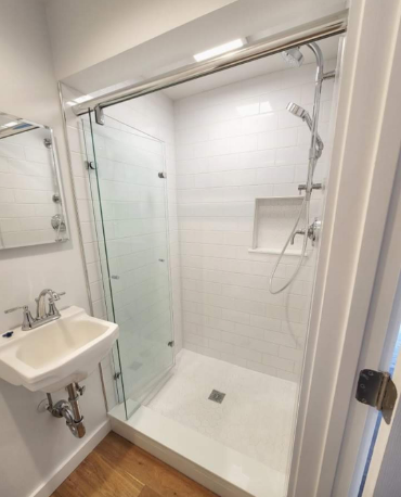 This is a bi-folding or "accordian" shower door with a Hydroslide bar across the top supporting the weight of the sliding glass while allowing for the maximum possible opening in a small space.