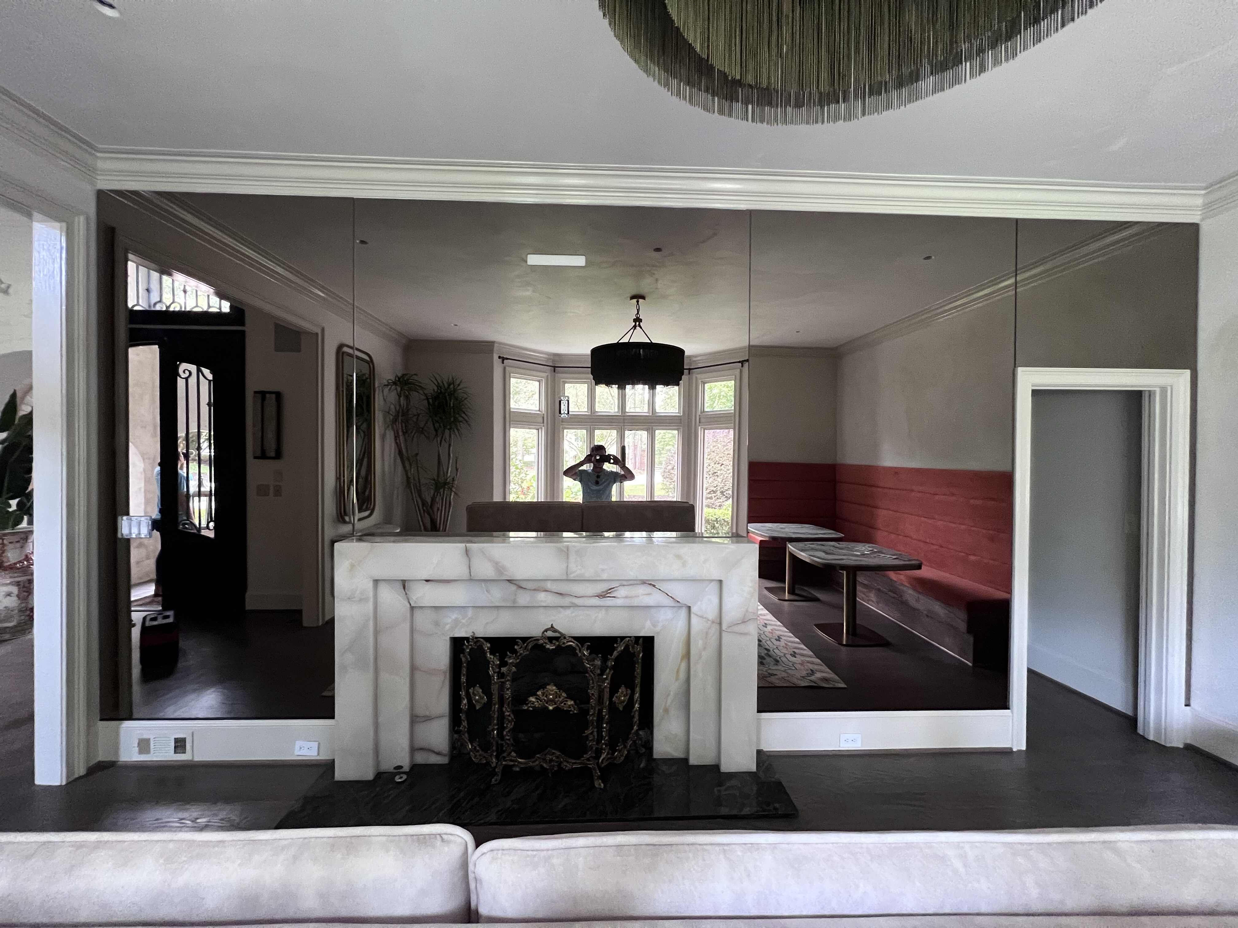 This bronze mirror wall was cut custom to surround a marble fireplace and accept mounting brackets for a custom commissioned art piece. What a stunning project! We are thrilled to have been a small part of it!